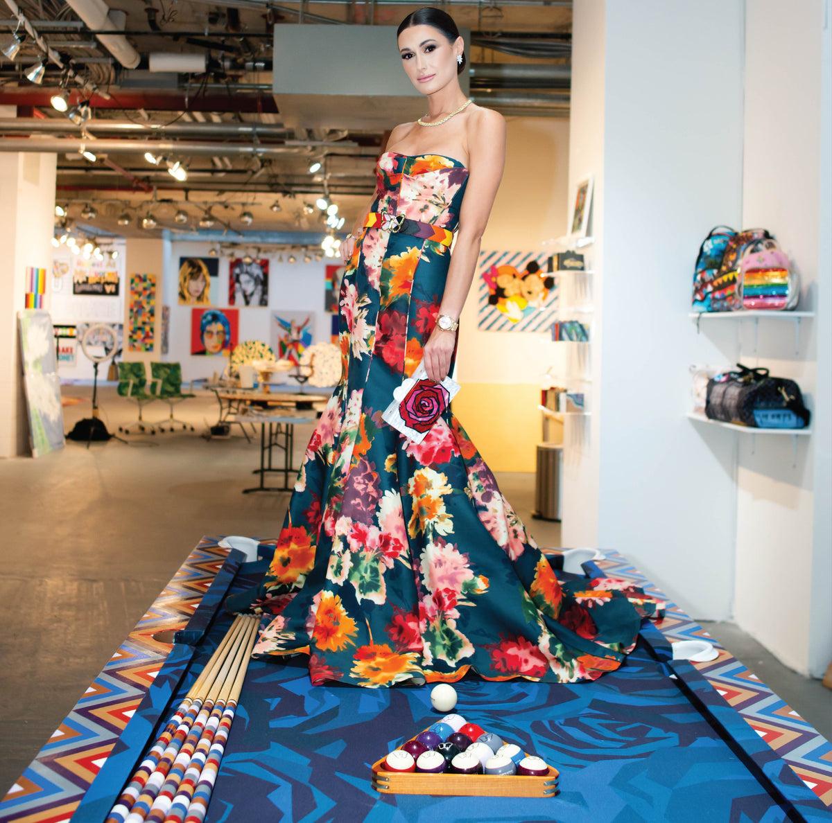 Model in a floral gown standing on the painted pool table