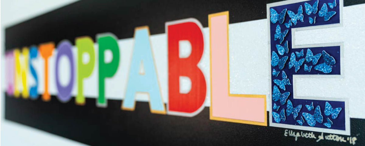 Painted UNSTOPPABLE lettering on a black wall