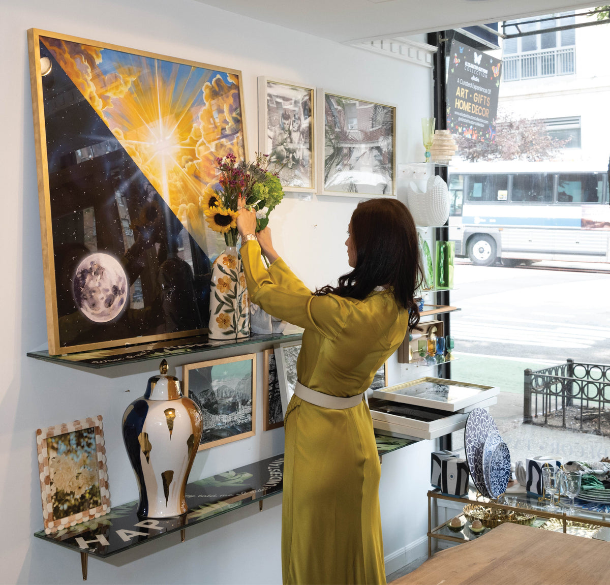 Elizabeth Sutton hanging artwork inside the atelier