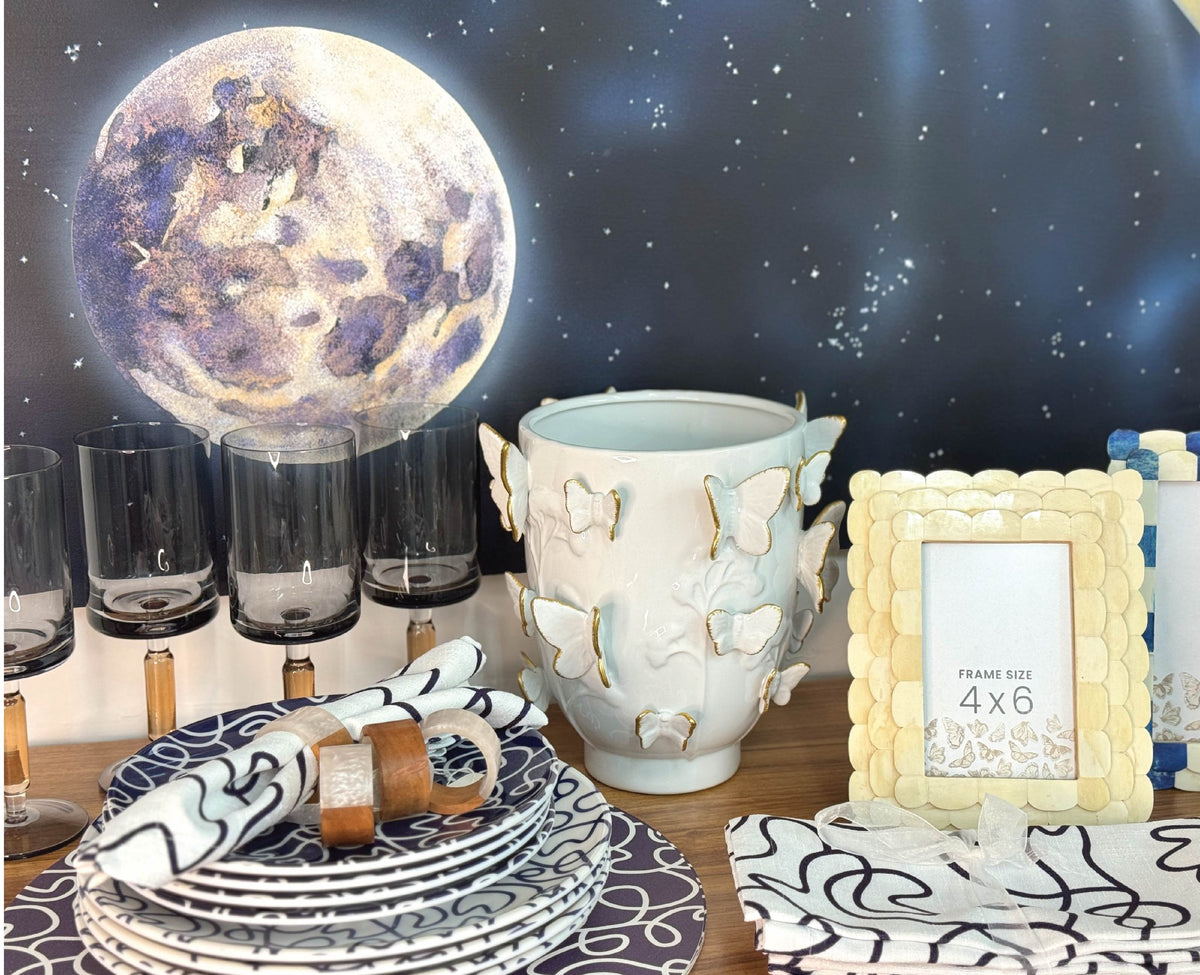 Moon artwork styled with dinnerware and a frame