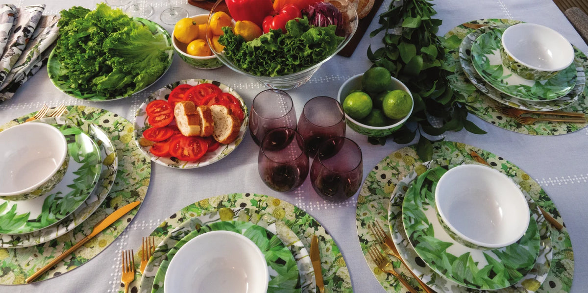 Table set with green palm print melamine dinnerware and fresh produce